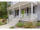 Close-up of the charming front porch with white railings, a bright green door, and meticulously maintained landscaping at 4416 Thistlehill Ct, Raleigh, NC 27616