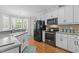 Modern kitchen features granite countertops, stainless steel appliances, and white cabinetry at 4416 Thistlehill Ct, Raleigh, NC 27616