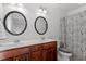 Bathroom with dual sinks, framed mirrors, and decorative shower curtain at 4605 All Points View Way, Raleigh, NC 27614
