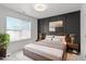 Modern bedroom featuring black accent wall, large window, hardwood floors, and neutral decor at 4605 All Points View Way, Raleigh, NC 27614