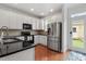 Updated kitchen with stainless steel appliances, black countertops, and white cabinets at 4605 All Points View Way, Raleigh, NC 27614