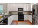 Updated kitchen with stainless steel appliances, black countertops, and white cabinets at 4605 All Points View Way, Raleigh, NC 27614