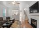 Cozy living room with fireplace, hardwood floors, and a view to kitchen and stairs at 4605 All Points View Way, Raleigh, NC 27614