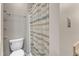 Bright bathroom with a white toilet and striped shower curtain at 4658 Fawnbrook Cir, Raleigh, NC 27612