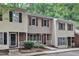 Inviting townhome exterior with brick details, manicured shrubbery, and quaint white picket fence at 4658 Fawnbrook Cir, Raleigh, NC 27612