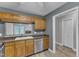 Kitchen with stainless steel dishwasher, wooden cabinets, and open view into living area at 4658 Fawnbrook Cir, Raleigh, NC 27612