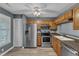 Well-lit kitchen with modern appliances, wood cabinetry, and vinyl floors at 4658 Fawnbrook Cir, Raleigh, NC 27612