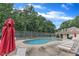 Inviting pool area featuring lounge chairs, umbrellas and a surrounding tree line at 4658 Fawnbrook Cir, Raleigh, NC 27612