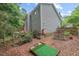 Spacious backyard with garden, putting green, and deck of the home surrounded by mature trees at 5 Providence Ridge Ln, Durham, NC 27713