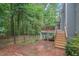 Backyard with brick patio and steps leading to the deck of this charming home at 5 Providence Ridge Ln, Durham, NC 27713