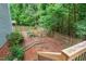 Backyard with brick patio, wood fence, landscaped area for a garden and mature trees at 5 Providence Ridge Ln, Durham, NC 27713