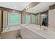 Bright bathroom with double vanity, soaking tub, glass shower, and large window for ample natural light at 5 Providence Ridge Ln, Durham, NC 27713