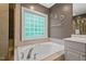 Bathroom featuring a soaking tub with chrome fixtures and a glass block window for ample natural light at 5 Providence Ridge Ln, Durham, NC 27713
