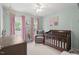 Cozy Bedroom with light blue walls, pink curtains, and a dark wood crib, creating a serene atmosphere at 5 Providence Ridge Ln, Durham, NC 27713