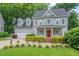 Traditional two-story home boasts lush landscaping, a covered porch, and an attached two-car garage at 5 Providence Ridge Ln, Durham, NC 27713