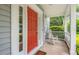 Close-up of the front porch with a bright red door and a classic white rocking chair at 5 Providence Ridge Ln, Durham, NC 27713