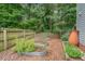 Backyard garden area with metal planters and wood fence surrounded by mature trees at 5 Providence Ridge Ln, Durham, NC 27713