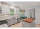 Eat-in kitchen featuring white cabinets, granite countertops, stainless appliances, and a butcher block island at 5 Providence Ridge Ln, Durham, NC 27713