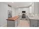 Bright kitchen features stainless appliances, white cabinets, and center island with butcher block countertop at 5 Providence Ridge Ln, Durham, NC 27713