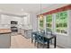 Eat-in kitchen featuring white cabinets, stainless steel appliances, and views of the backyard at 5 Providence Ridge Ln, Durham, NC 27713