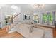 Open-concept living room with hardwood floors, a large sectional sofa, and staircase views at 5 Providence Ridge Ln, Durham, NC 27713
