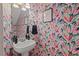 Stylish powder room with vibrant wallpaper and a pedestal sink, blending modern design with artistic flair at 5 Providence Ridge Ln, Durham, NC 27713