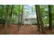 Two-story home with light siding and a welcoming porch nestled among mature trees and natural foliage at 516 Ryan Rd, Cary, NC 27511