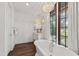 Elegant bathroom featuring a freestanding tub, wood-trimmed windows, and a stylish chandelier at 523 Vick Ave, Raleigh, NC 27612