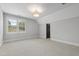 Bright bedroom with neutral carpet, a large window, and stylish light fixture at 523 Vick Ave, Raleigh, NC 27612