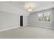 Spacious bedroom with neutral carpet, large window, and stylish light fixture at 523 Vick Ave, Raleigh, NC 27612