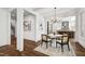 Dining area featuring hardwood floors, modern chandelier and open access to the staircase and kitchen at 523 Vick Ave, Raleigh, NC 27612