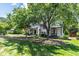 Charming home's front yard with mature trees, a meticulously kept lawn, and inviting walkway leading to the front door at 523 Vick Ave, Raleigh, NC 27612