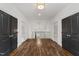Bright hallway showcasing hardwood floors, with black doors and contemporary lighting fixtures at 523 Vick Ave, Raleigh, NC 27612