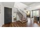 Well-lit hallway featuring hardwood floors, a staircase with iron railing, and stylish decor at 523 Vick Ave, Raleigh, NC 27612