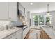 Bright kitchen featuring modern appliances, granite countertops, a gas range, mosaic tile backsplash, and hardwood floors at 523 Vick Ave, Raleigh, NC 27612
