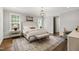 Spacious main bedroom with a large bed, a decorative rug, and natural light from two windows at 523 Vick Ave, Raleigh, NC 27612