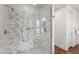 Luxurious shower with marble tiling, modern fixtures, and a glass enclosure showcasing a chandelier at 523 Vick Ave, Raleigh, NC 27612