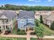 Aerial view of blue two-story home with stone accents, mature landscaping, and a charming front porch at 533 Duchart Ln, Fuquay Varina, NC 27526
