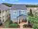 Aerial view of blue two-story home featuring a yellow front door and a landscaped yard at 533 Duchart Ln, Fuquay Varina, NC 27526