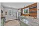 Modern kitchen with stainless steel appliances, granite countertops, and natural wood accent wall at 533 Duchart Ln, Fuquay Varina, NC 27526