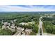 Scenic aerial view of townhomes with mature trees and a city skyline in the distance under a blue sky at 5503 Silver Moon Ln, Raleigh, NC 27606