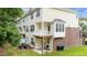 A back view reveals a small patio, a balcony, and a well-manicured lawn surrounded by mature trees at 5503 Silver Moon Ln, Raleigh, NC 27606