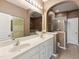 Bright bathroom with double sinks, arched mirrors, and walk-in shower at 5503 Silver Moon Ln, Raleigh, NC 27606