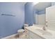 Bathroom with blue walls, tile flooring, white vanity, toilet and shower with grab bar at 5503 Silver Moon Ln, Raleigh, NC 27606