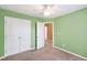 Bedroom featuring green walls, carpet, double closet and ceiling fan at 5503 Silver Moon Ln, Raleigh, NC 27606