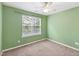 Inviting bedroom with green walls, plush carpet, and natural light from a single window at 5503 Silver Moon Ln, Raleigh, NC 27606