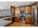 Well-appointed kitchen with stainless steel appliances, wood cabinets, and ample counter space with tile backsplash at 5503 Silver Moon Ln, Raleigh, NC 27606