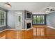 Spacious living room showcasing a charming fireplace, beautiful hardwood floors, and a door to the outside at 5503 Silver Moon Ln, Raleigh, NC 27606