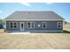 Spacious backyard with a gray vinyl siding house, and a concrete patio at 56 Braddock Ct, Garner, NC 27529
