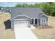Aerial view of gray house with white garage door, a dark gray roof and manicured yard at 56 Braddock Ct, Garner, NC 27529